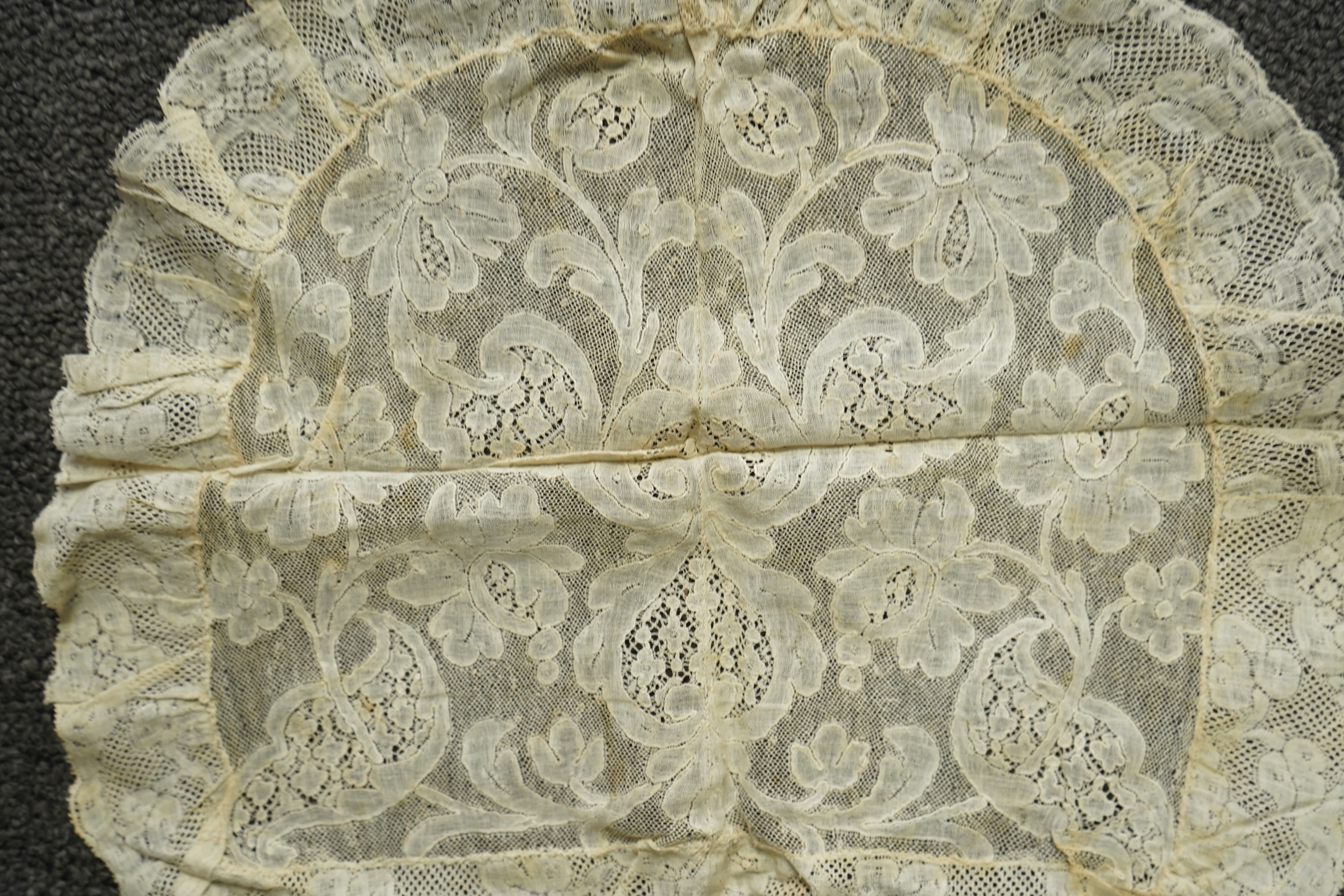 A collection of 18th century needle and bobbin lace. Including an 18th century wide pair of joined Valenciennes lace lappets, a similar 18th century cap back, an ornately worked Point de Alencon cap crown and another sim